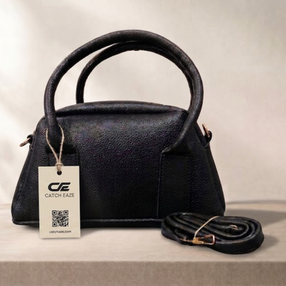 Black handbag with a matching strap on a light background, featuring a 'Catch Eaze' tag.