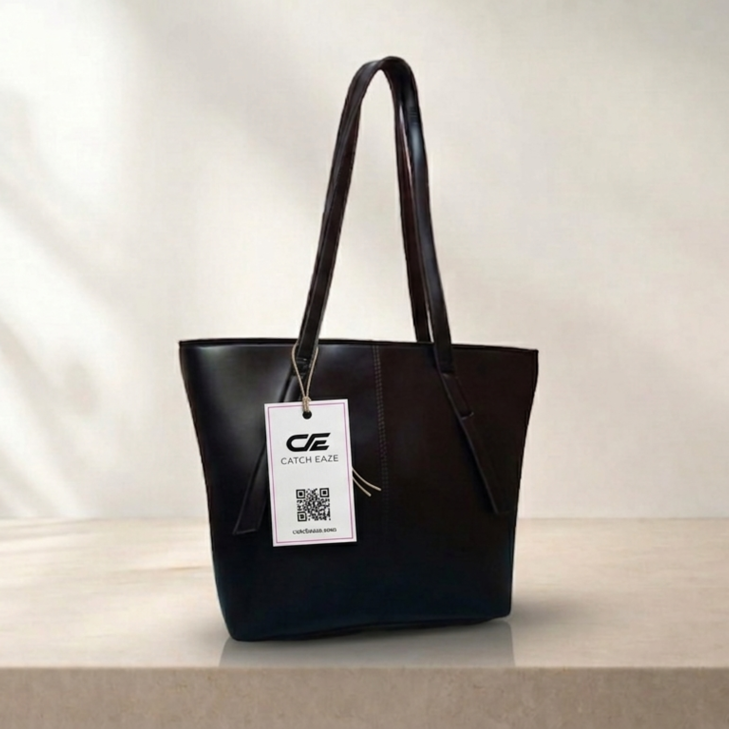 Black handbag with a visible brand tag on a neutral background