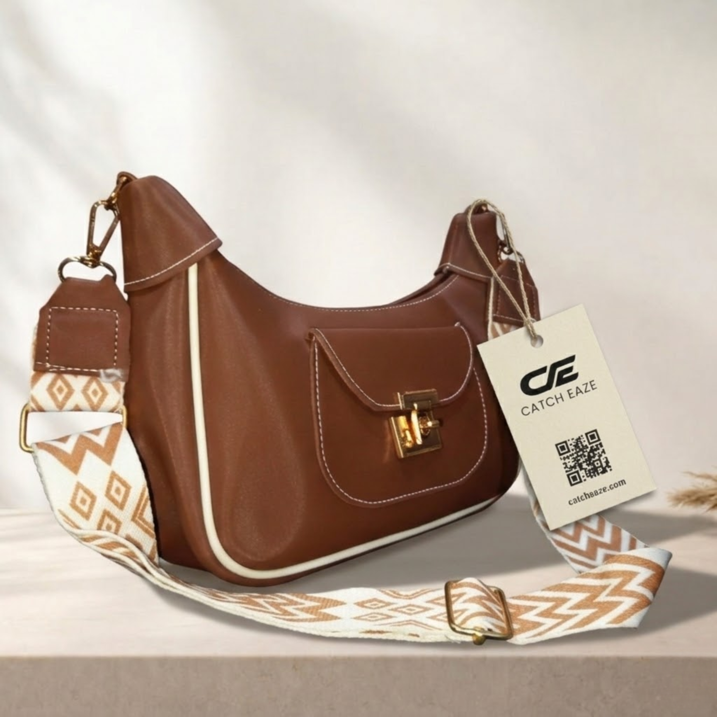 Brown handbag with patterned strap and Catcheaze tag on a light background