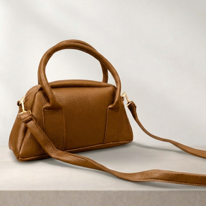 Brown leather handbag with a matching strap on a light gray background