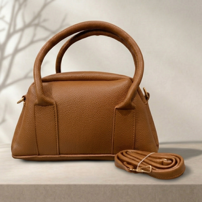 Brown leather handbag with matching strap on a light background