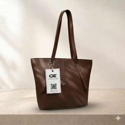 Brown tote bag with a visible brand tag on a neutral background