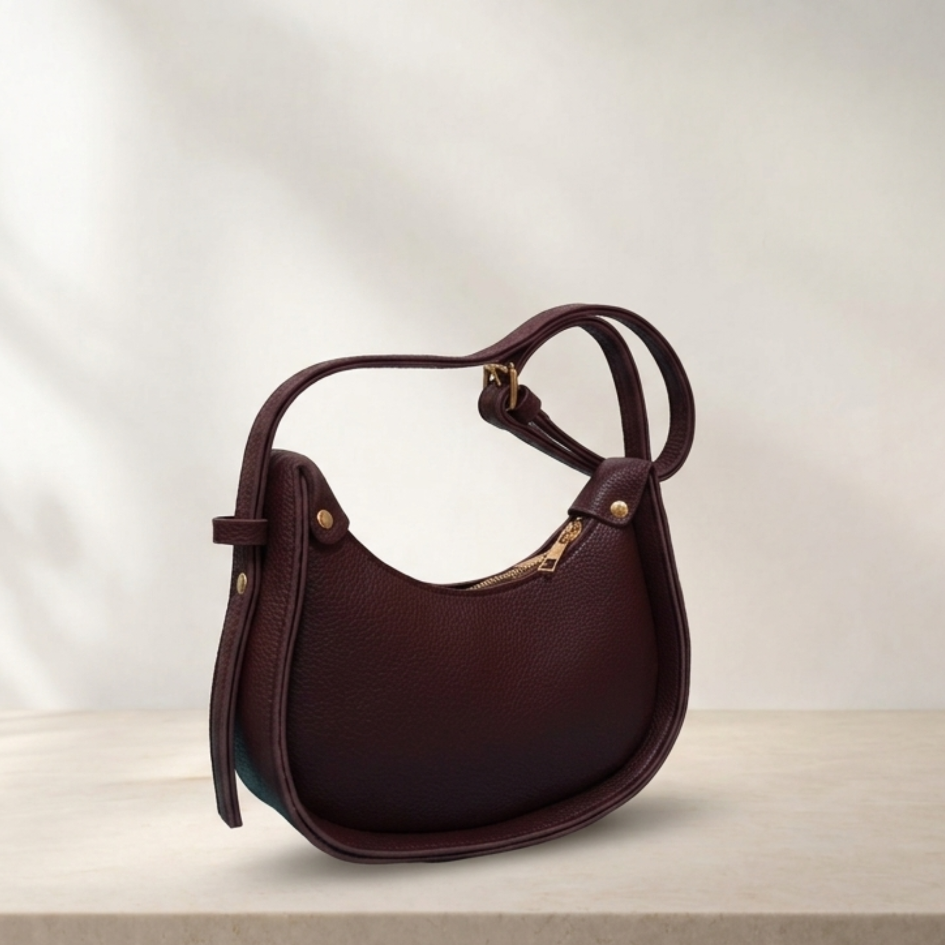 Brown leather handbag on a light wooden surface with a neutral background