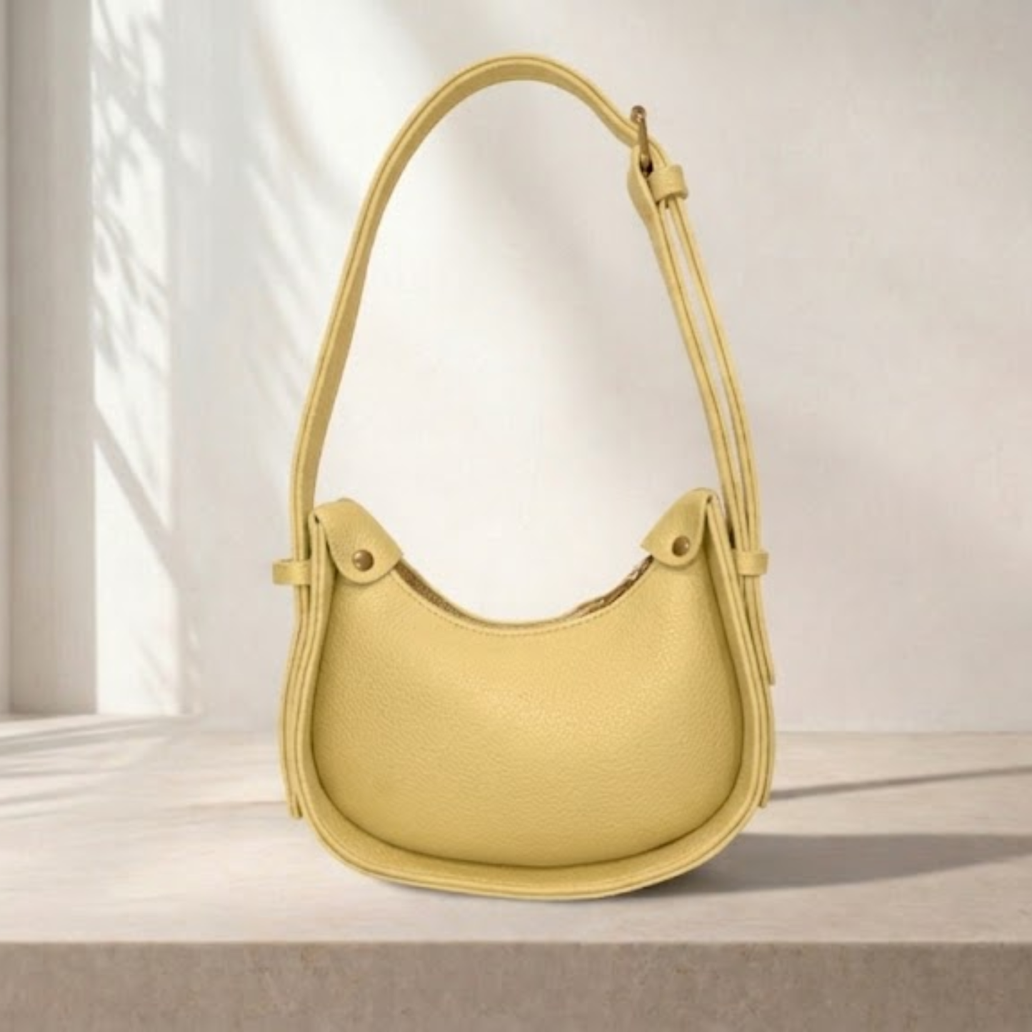 Yellow handbag on a light beige surface with a neutral background