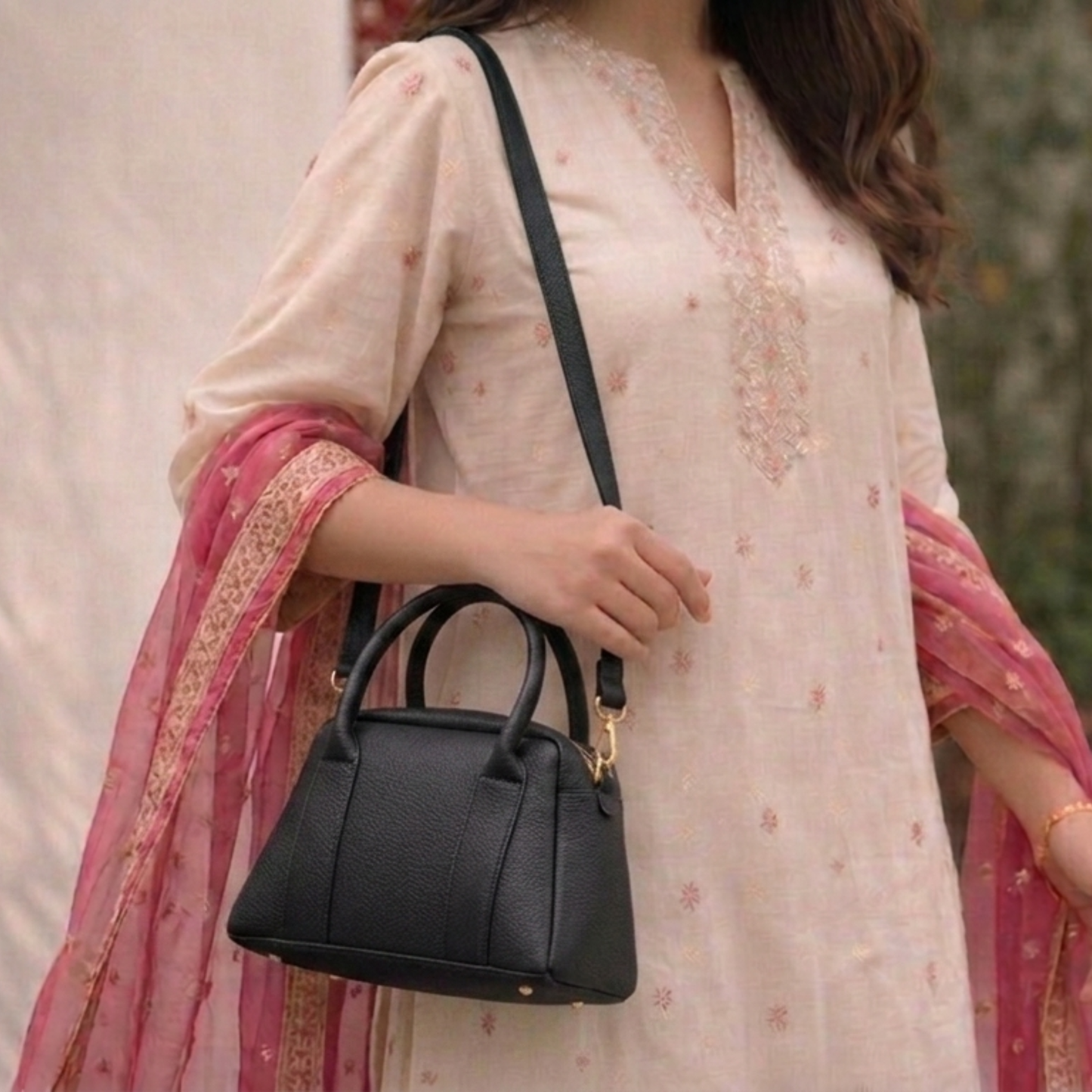 Woman holding a black handbag with a blurred background