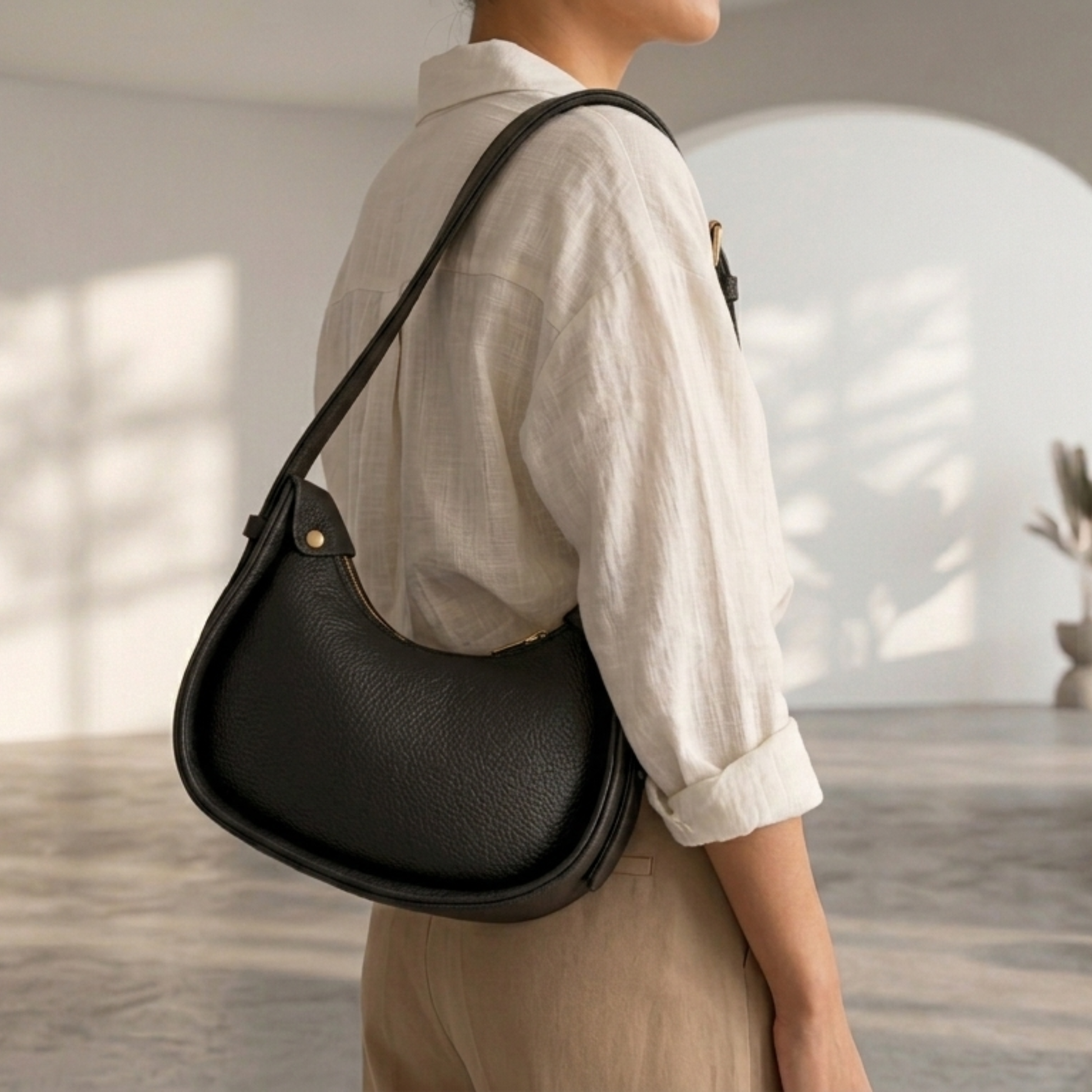 Person wearing a black shoulder bag in an indoor setting