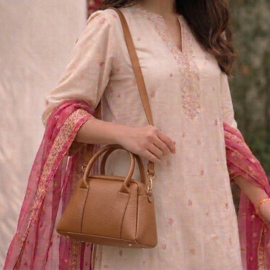 Woman holding a brown handbag with a blurred background