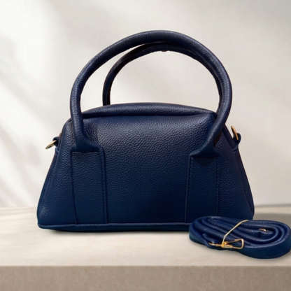 Navy blue handbag with matching strap on a light background