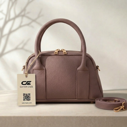 Purple handbag with matching strap on a light surface, branded 'Catch Eaze'.